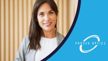 Smiling businesswoman in professional attire standing next to a Proven Optics logo, representing IT financial management and automation in enterprise budgeting.